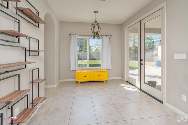 unfurnished dining area with light tile patterned floors and an inviting chandelier