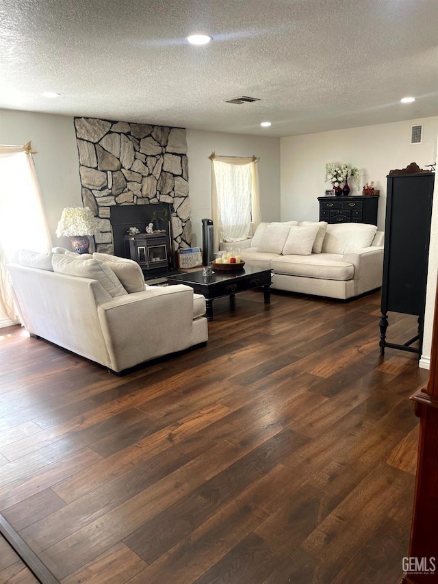 living area featuring visible vents, a textured ceiling, and wood finished floors