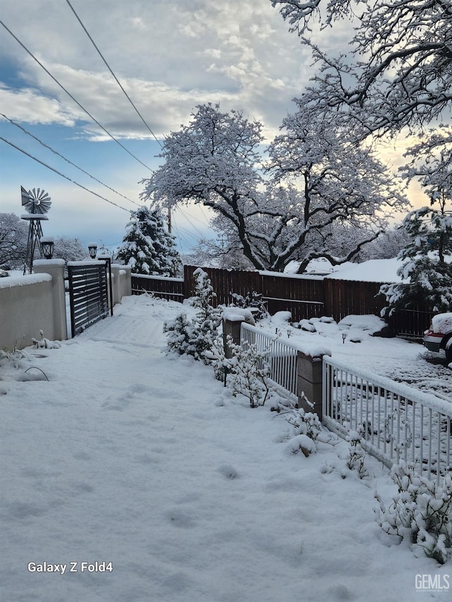 yard covered in snow with fence