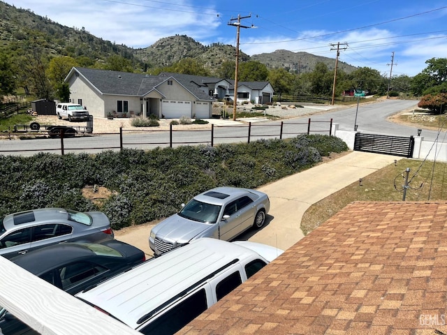 view of car parking with a mountain view and fence