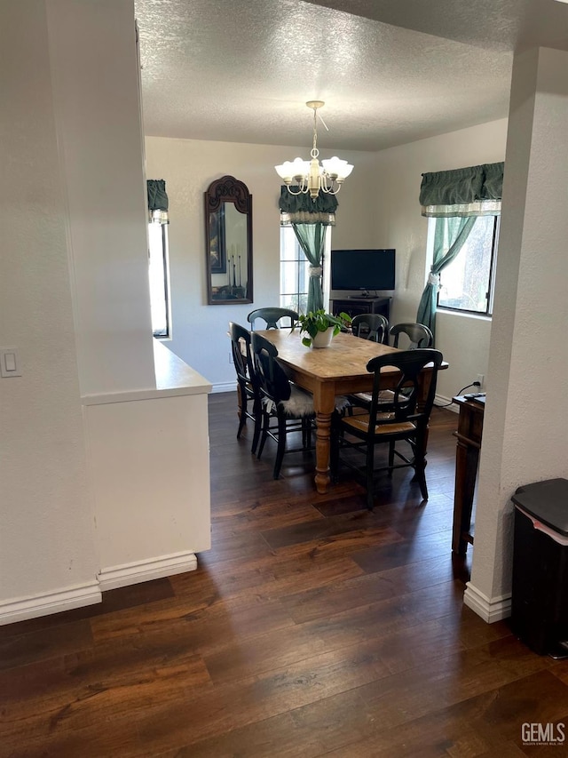 dining space featuring an inviting chandelier, a textured ceiling, baseboards, and dark wood-style floors