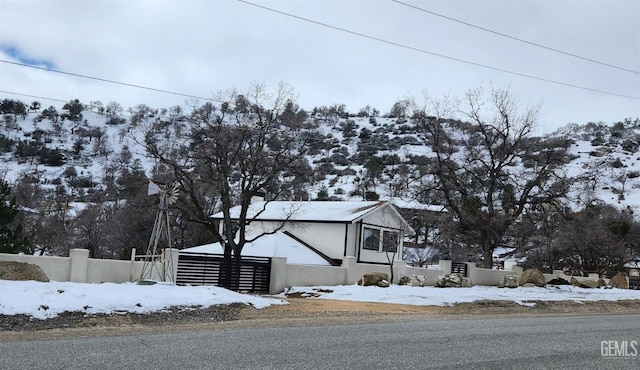 snow covered property with fence