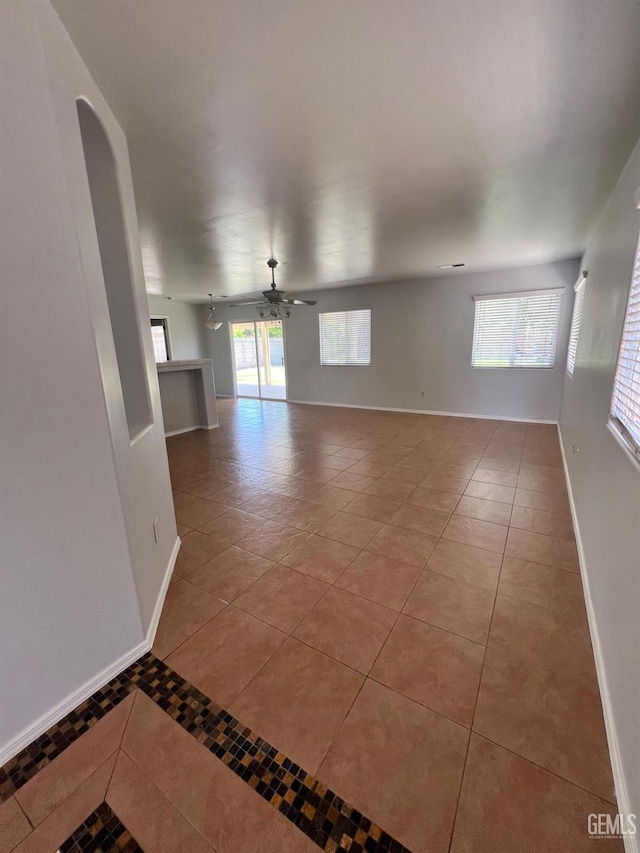 9809 Battersea Park Dr, Bakersfield, CA 93312 - spare room with light tile patterned flooring, baseboards, a ceiling fan, and arched walkways