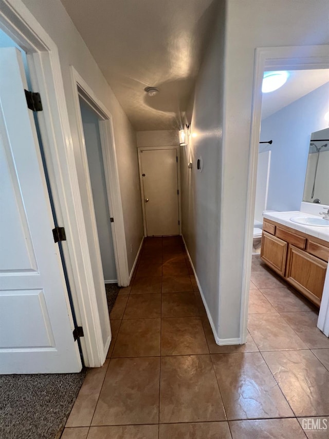 9809 Battersea Park Dr, Bakersfield, CA 93312 - hallway featuring a sink, light tile patterned floors, and baseboards