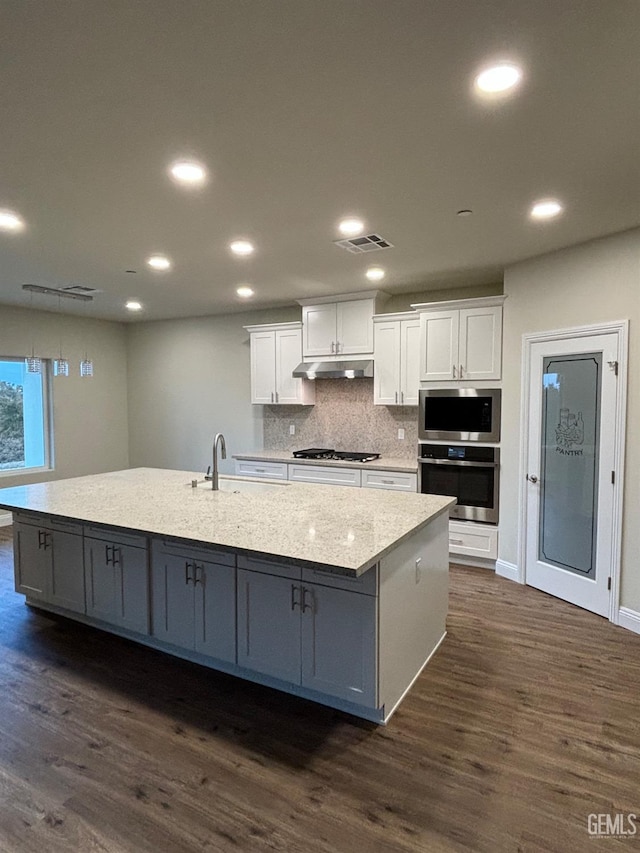 kitchen with white cabinetry, dark hardwood / wood-style flooring, stainless steel appliances, and a large island