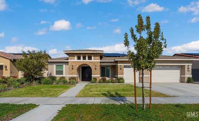 prairie-style home featuring driveway, a garage, roof mounted solar panels, a front lawn, and stucco siding