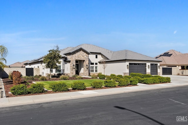 french provincial home with a garage, fence, stone siding, driveway, and stucco siding