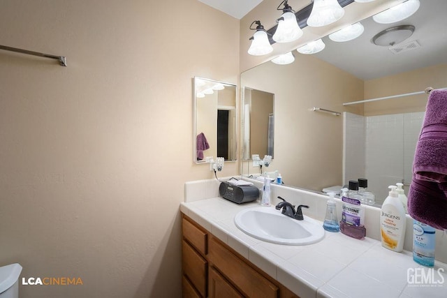 full bathroom with visible vents, vanity, and a shower