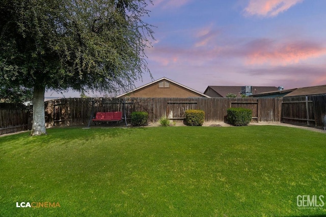 yard at dusk with a fenced backyard