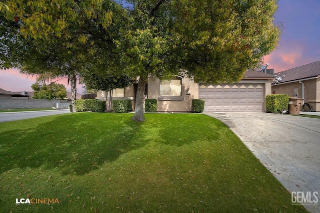 obstructed view of property with stucco siding, driveway, an attached garage, and a yard