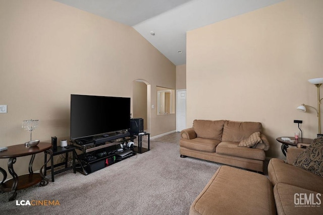 carpeted living room featuring arched walkways, high vaulted ceiling, and baseboards