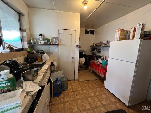 kitchen featuring white fridge and tile countertops