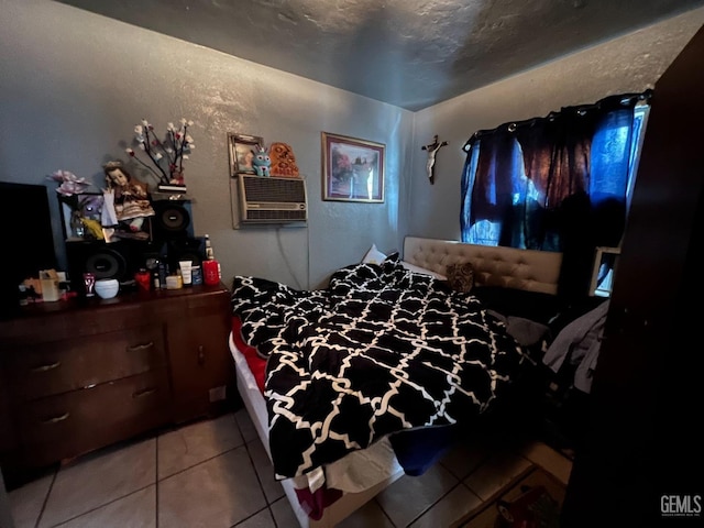 bedroom with a wall unit AC, a textured ceiling, and light tile patterned floors