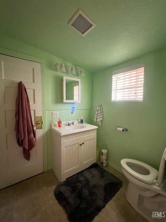 220 Tyler St, Taft, CA 93268 - half bathroom featuring toilet, vanity, a textured ceiling, and tile patterned flooring