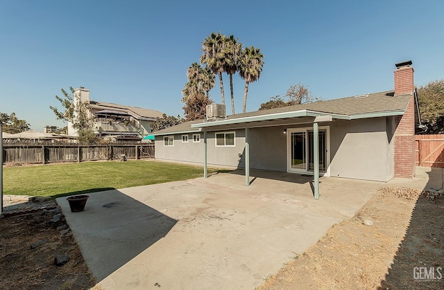 back of property with a lawn, central AC, and a patio