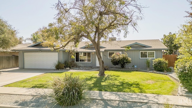 ranch-style home featuring a garage and a front lawn