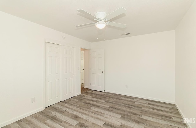 unfurnished bedroom featuring ceiling fan, a closet, and light hardwood / wood-style floors