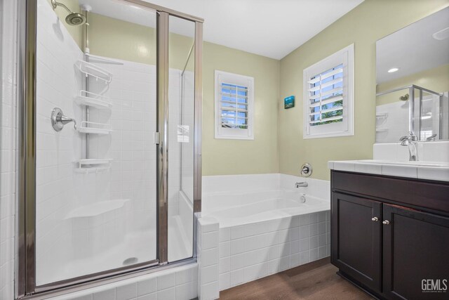 8113 Mcgraw Hill Dr, Bakersfield, CA 93311 - full bathroom featuring a garden tub, vanity, wood finished floors, and a stall shower