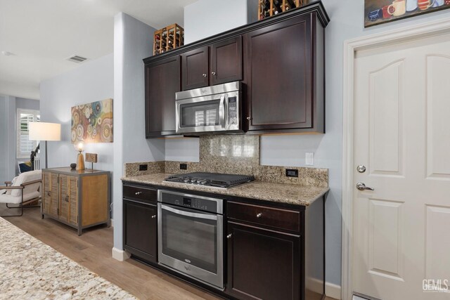 8113 Mcgraw Hill Dr, Bakersfield, CA 93311 - kitchen featuring light wood finished floors, stainless steel appliances, backsplash, visible vents, and dark brown cabinetry