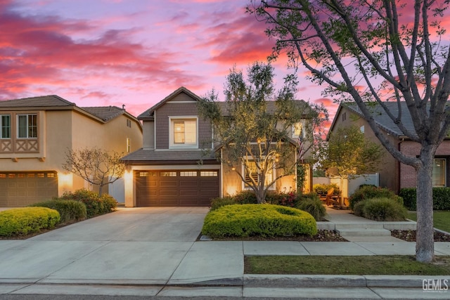 traditional-style house with stucco siding, concrete driveway, and a garage