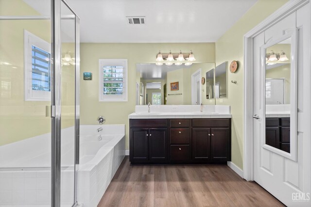 8113 Mcgraw Hill Dr, Bakersfield, CA 93311 - bathroom featuring a shower stall, wood finished floors, visible vents, a sink, and a garden tub