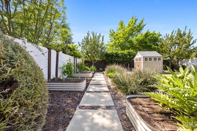 8113 Mcgraw Hill Dr, Bakersfield, CA 93311 - view of yard with a fenced backyard, an outbuilding, a storage shed, and a vegetable garden