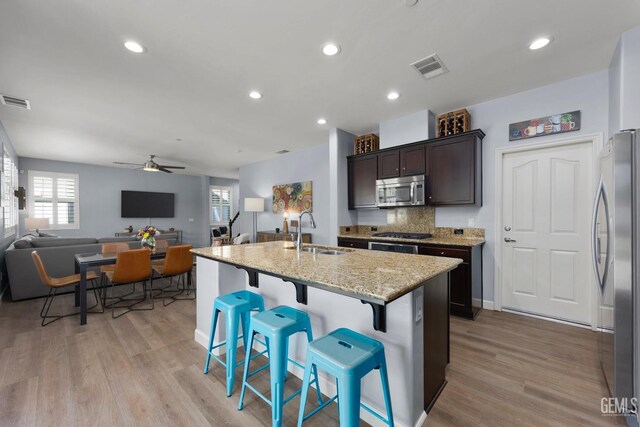 8113 Mcgraw Hill Dr, Bakersfield, CA 93311 - kitchen featuring a ceiling fan, a sink, open floor plan, dark brown cabinetry, and stainless steel appliances