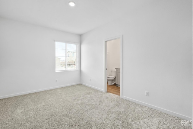 unfurnished bedroom with light carpet and ensuite bathroom