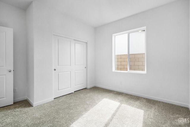 unfurnished bedroom with a closet and carpet flooring