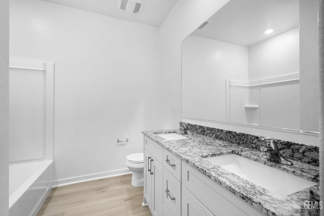 bathroom featuring hardwood / wood-style flooring, vanity, and toilet