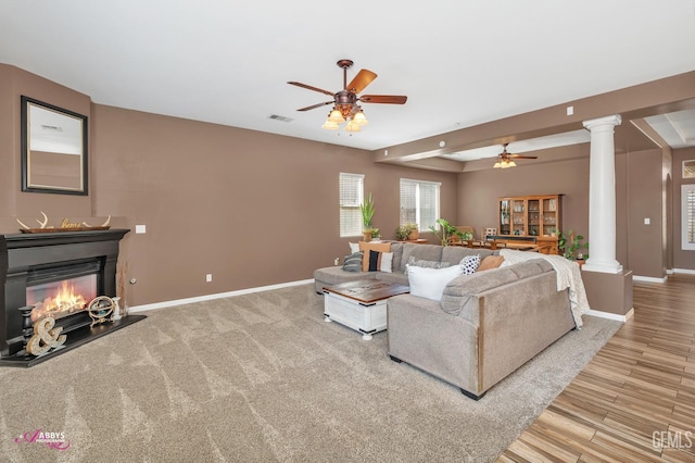 22 Emerald Isle Way, Bakersfield, CA 93314 - living room featuring ornate columns, visible vents, a ceiling fan, baseboards, and a glass covered fireplace
