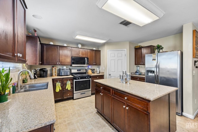 9301 Cobble Mountain Rd, Bakersfield, CA 93313 - kitchen with stainless steel appliances, a sink, a center island, light stone countertops, and dark brown cabinetry