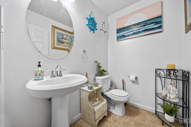 9301 Cobble Mountain Rd, Bakersfield, CA 93313 - bathroom featuring baseboards and toilet