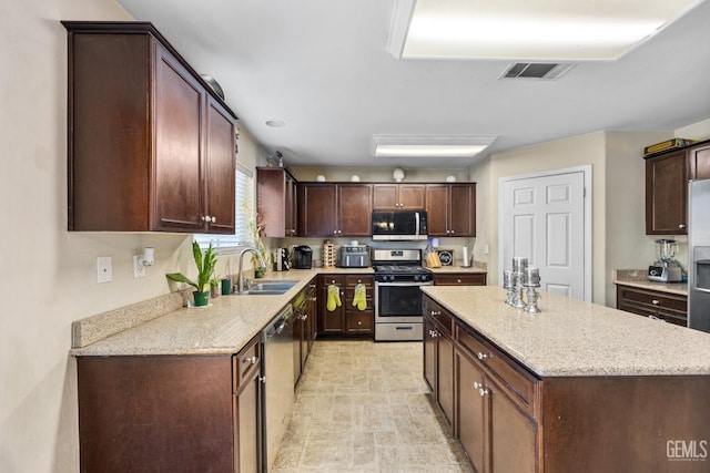 9301 Cobble Mountain Rd, Bakersfield, CA 93313 - kitchen featuring stainless steel appliances, a center island, a sink, and light stone countertops