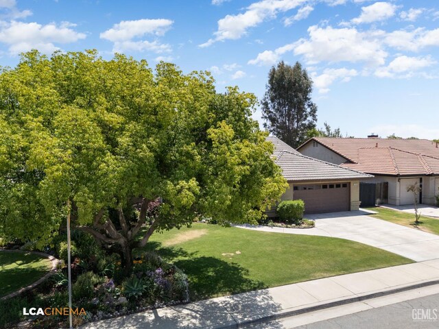 13909 Las Entradas, Bakersfield, CA 93314 - view of front facade with a tiled roof, a garage, concrete driveway, a front yard, and stucco siding