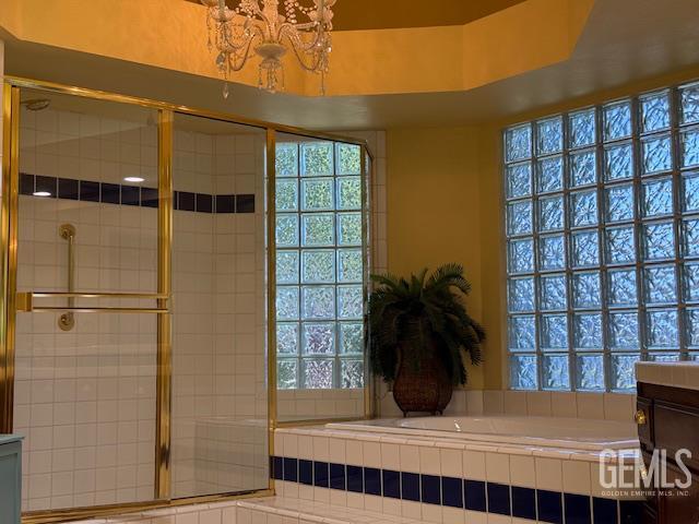 2012 Calle Las Brisas, Bakersfield, CA 93309 - bathroom featuring a garden tub, a stall shower, a chandelier, vanity, and healthy amount of natural light