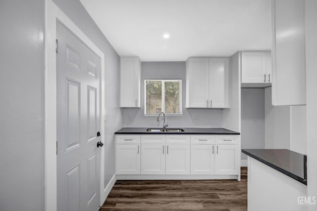 kitchen featuring white cabinets, dark hardwood / wood-style flooring, and sink