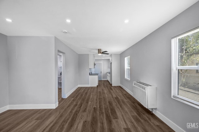 hall with radiator heating unit and dark wood-type flooring