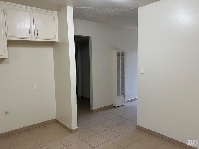 1026 Flower St, Bakersfield, CA 93305 - empty room featuring a heating unit, light tile patterned flooring, and a textured ceiling