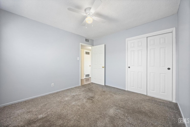 unfurnished bedroom featuring ceiling fan, carpet floors, a closet, and a textured ceiling