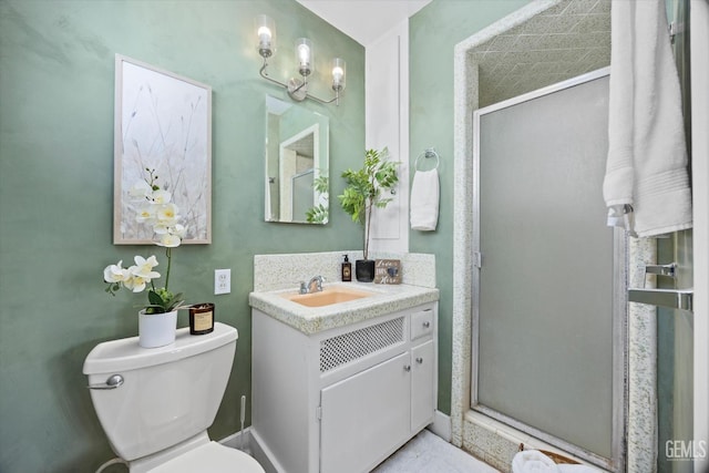 bathroom with vanity, a shower with door, and toilet