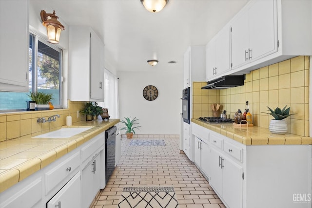 kitchen with white cabinetry, sink, backsplash, tile counters, and black appliances