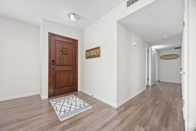 foyer with light hardwood / wood-style flooring and a textured ceiling