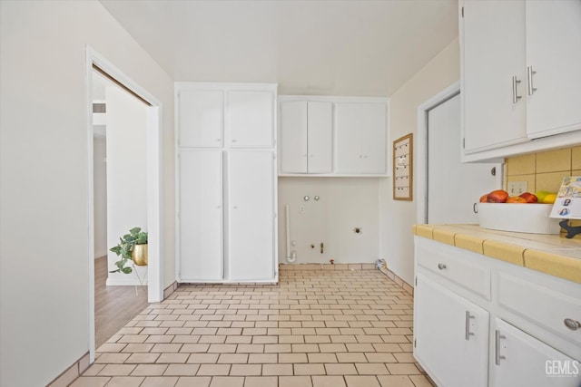 kitchen featuring white cabinetry, backsplash, and tile countertops