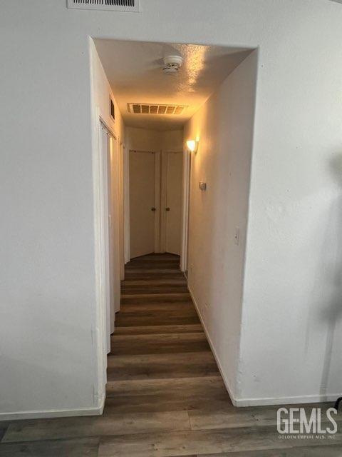 1024 Hazelnut St, Wasco, CA 93280 - hall with dark wood-type flooring and baseboards