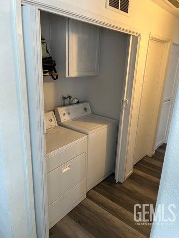 1024 Hazelnut St, Wasco, CA 93280 - laundry area with dark wood-style flooring, cabinet space, and independent washer and dryer