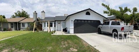 1024 Hazelnut St, Wasco, CA 93280 - ranch-style home with a garage, driveway, and a front lawn