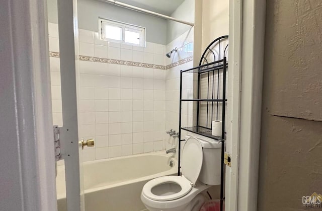 bathroom with tiled shower / bath and toilet