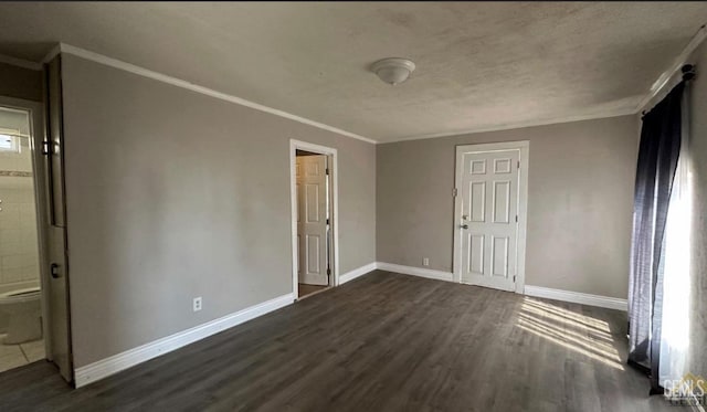 unfurnished bedroom with ensuite bath, dark hardwood / wood-style flooring, and ornamental molding