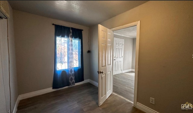 spare room with dark hardwood / wood-style flooring and a textured ceiling